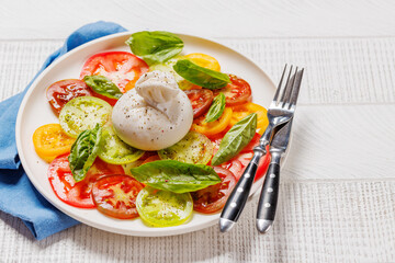 Fresh burrata served on slices of colorful tomatoes