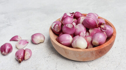 shallot onions on the wooden bowl isolated on grey background. peeled red onion
