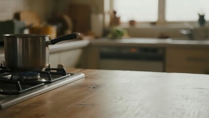 Empty wooden table with soft light, blurred kitchen behind. Simplicity and warmth in a quiet moment.