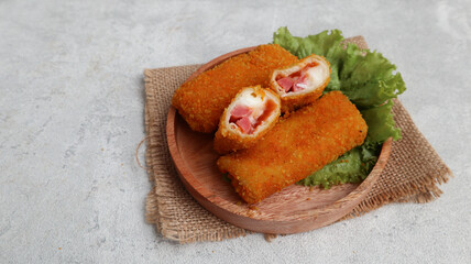 risoles mayo, the contents of mayonnaise, sausages and carrots, served on a wooden plate, on a grey background. selective focus. Breakfast snack
