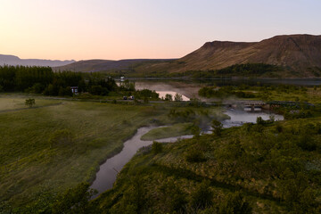 Sunrise illuminating foggy river and lake in mosfellsbær, iceland