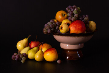 Still life of fruits on a black background, autumn harvest, than