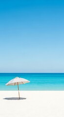 Fototapeta premium Serene Tropical Beach Scene with White Sand Clear Blue Sky and Turquoise Ocean Featuring a Beach Umbrella