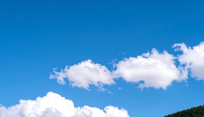 Obraz premium Vivid blue sky with fluffy white cumulus clouds at the horizon