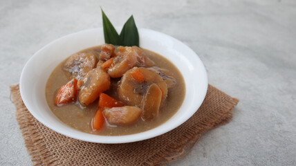 Kolak Pisang Ubi is Banana Sweet Potato Compote. Popular Indonesian Dessert Made from Coconut milk, Palm Sugar and Pandanus Leaves. Very popular during Ramadhan. served on white bowl