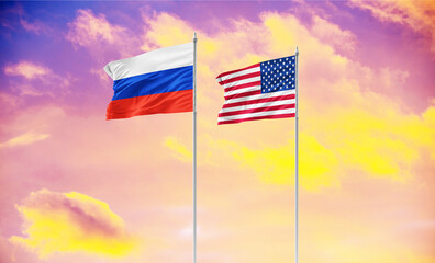 Flags of Russia and the United States waving together against a blue sky with clouds. Concept image symbolizing diplomatic relations, international politics, or a meeting between world leaders, such a