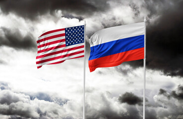 Flags of Russia and the United States waving together against a blue sky with clouds. Concept image symbolizing diplomatic relations, international politics, or a meeting between world leaders, such a