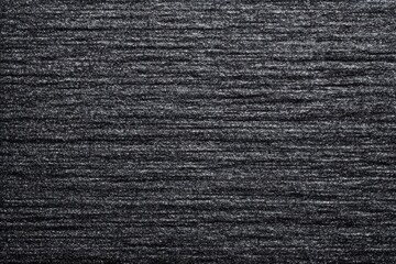 Dark textured fabric surface with horizontal lines and subtle shimmering effect