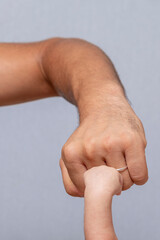Close-up of a father making a fist bump with his newborn son