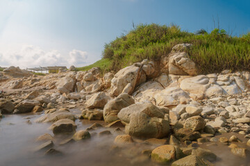 Cielo azul, rocas naranjas y pasto verde 