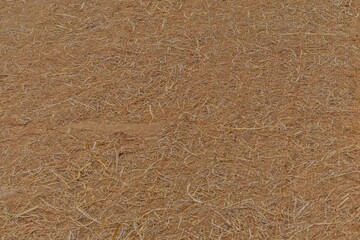 Close-up texture of natural coir erosion control matting used for slope stabilization and landscaping.