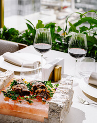 Fine dining outdoors with gourmet dish and wine in a modern setting