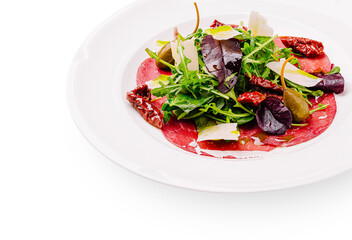 Fresh salad with cured meat and assorted greens served on a white plate