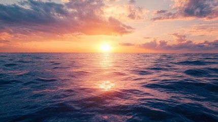 Fototapeta premium Sunset over the ocean, with warm light reflecting on the water.