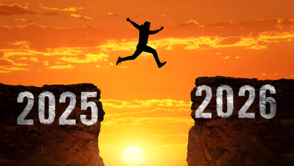 Silhouette man leaps across cliff gap at sunset jumping leaping