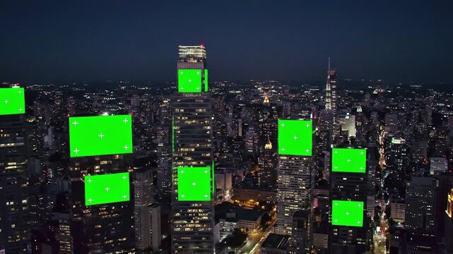 Aerial Top View of Night City with Four Vertical Green Screen Billboards on Skyscrapers