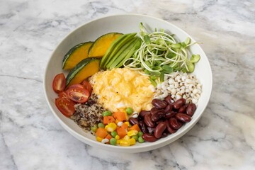 Vegetarian breakfast bowl with scrambled eggs and grains
