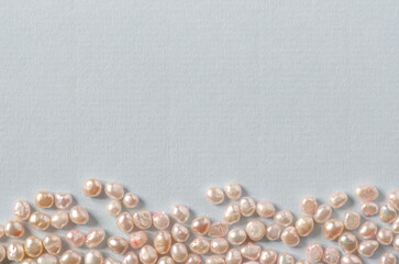 White pearls flat lay on pastel blue background