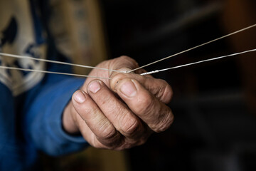 A fisherman ties knot in fishing line