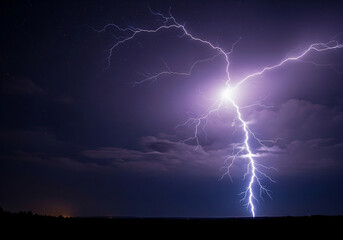 A dramatic lightning strike illuminates the stormy night sky over a dark, silhouetted landscape.