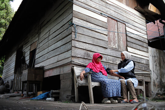Female Health Worker Checks Blood Pressure of Elderly Woman in Rural Area During Medical Visit - Powered by Adobe