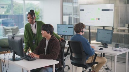 Focused manager provides helpful assistance to customer support representative within modern call center office, creating collaborative team focused on excellent support - Powered by Adobe