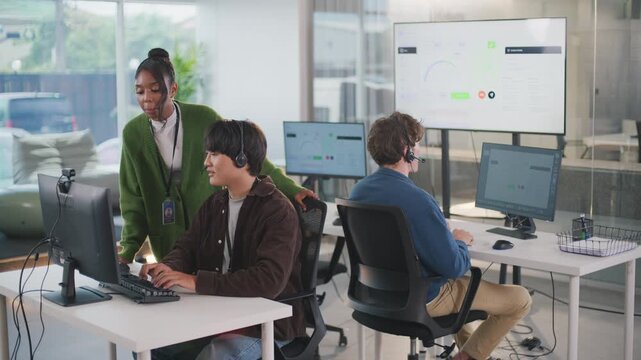 Focused manager provides helpful assistance to customer support representative within modern call center office, creating collaborative team focused on excellent support - Powered by Adobe