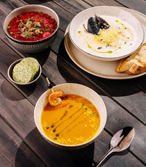 Delicious seafood and soup dishes presented on rustic wooden table