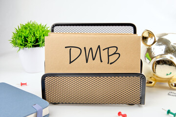 DMB text on paper next to piggy bank, notepad, flower on a white background