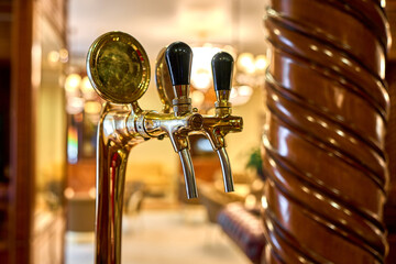 Close-up of a golden beer tap at a bar.