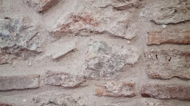 Detailed view of traditional limestone and brick wall with mortar and aged texture