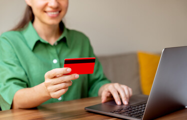Female making online purchase with credit card on laptop