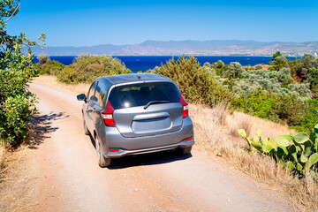 Gray car on an empty gravel road on the coast of Latchi, Cyprus, on the Akamas Peninsula. Road is a symbol of travel. © Tomasz
