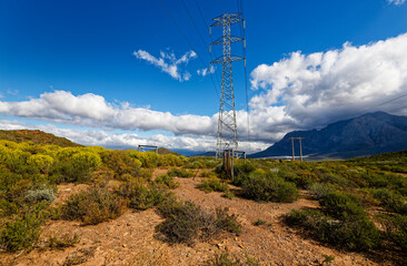 Obraz premium A view over the mountains around Worcester, Western Cape, South Africa, with electrical pylons in the foreground.