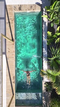 Woman swimming in a rooftop pool at a luxury resort