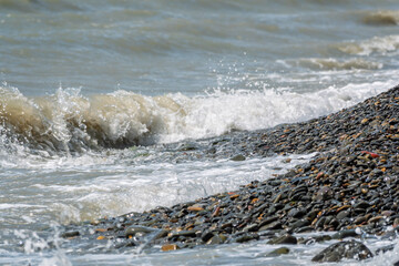 Sea water splashing over the stones on the beach