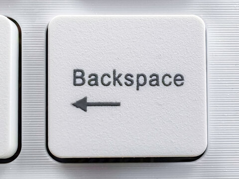 Close-up of a White "Backspace" Key on a Modern Silver Keyboard.