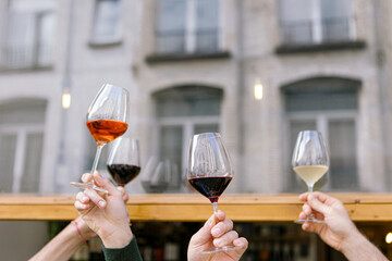 Friends raising wine glasses celebrating outdoors: wine tasting event