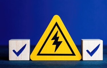 Yellow electrical hazard sign between two wooden blocks with checkmarks