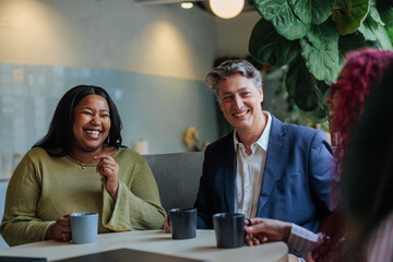 Business people enjoying coffee break and sharing a laugh together