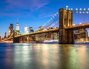 Obraz premium Night cityscape with iconic bridge and city skyline reflected in calm water