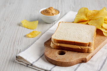 Homemade American Peanut Butter Sandwich and Potato Chips, side view.