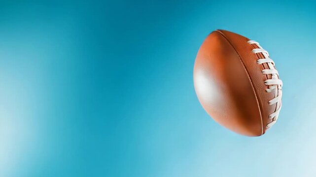 Soaring football against vibrant blue background capturing dynamic motion