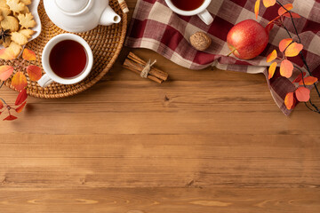 Cozy autumn tea arrangement featuring warm hues, seasonal decor, and wooden table background
