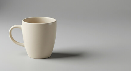 Obraz premium Minimalist Beige Ceramic Mug With Handle On A Light Gray Surface