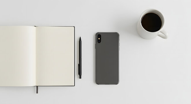Minimalist workspace setup with open notebook, pen, smartphone and coffee cup on white surface creating a clean and