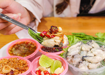 Delicious Oysters with Spicy Sauce and Herbs.