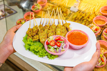 Grilled chicken wings and shish kebabs served on skewers with a delicious meal presentation
