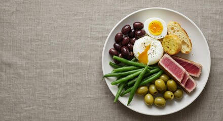 Delicious tuna niçoise salad on a white plate with fresh ingredients. Healthy eat concept for diet program. copy space