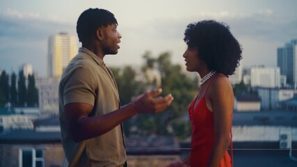 Black couple arguing on rooftop after party, dealing with relationship issues - Powered by Adobe